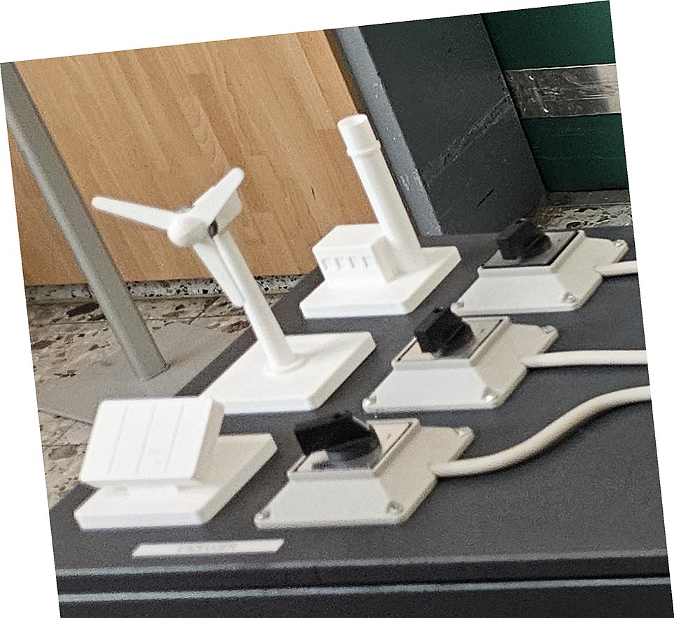 Nahaufnahme: Windrad, Gaskraftwerk und Solaranlage aus dem 3D-Drucker, daneben die Drehschalter